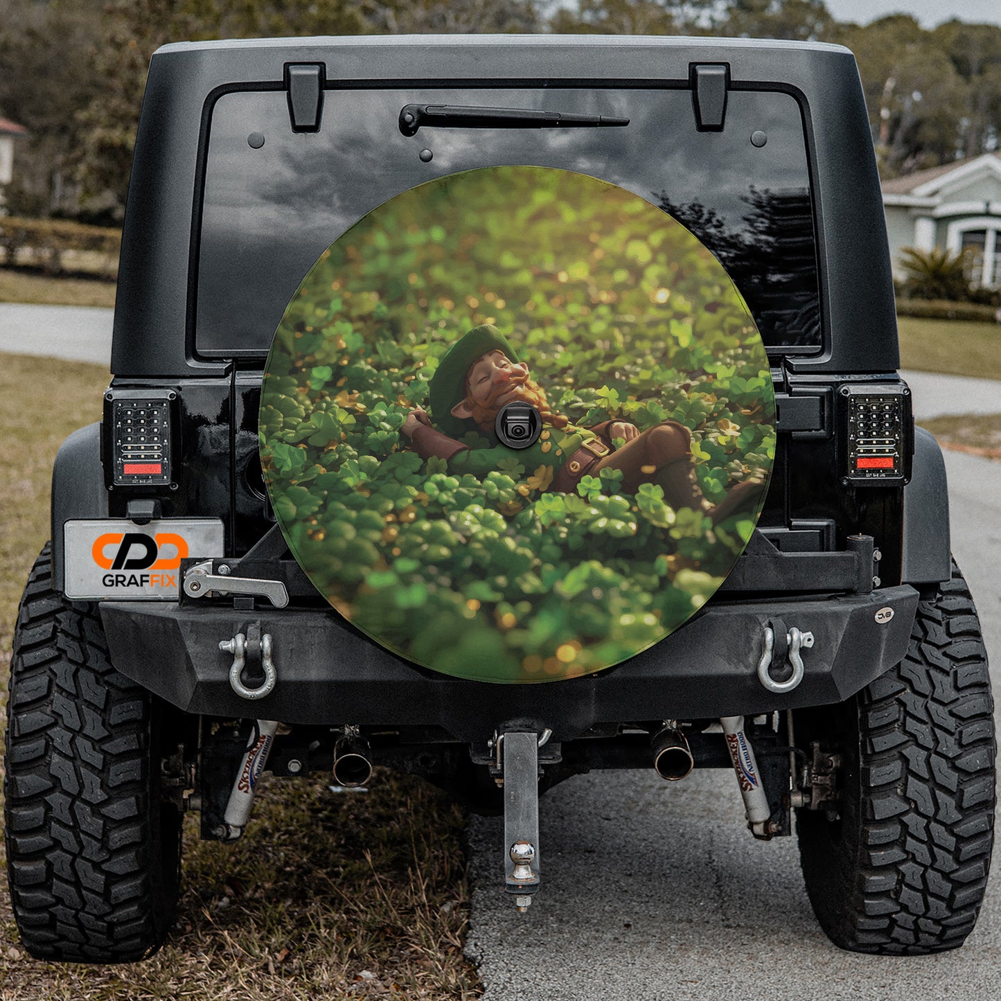a black Jeep Wrangler with a large, circular spare tire cover on the rear window, featuring a person lying in a field of flowers.