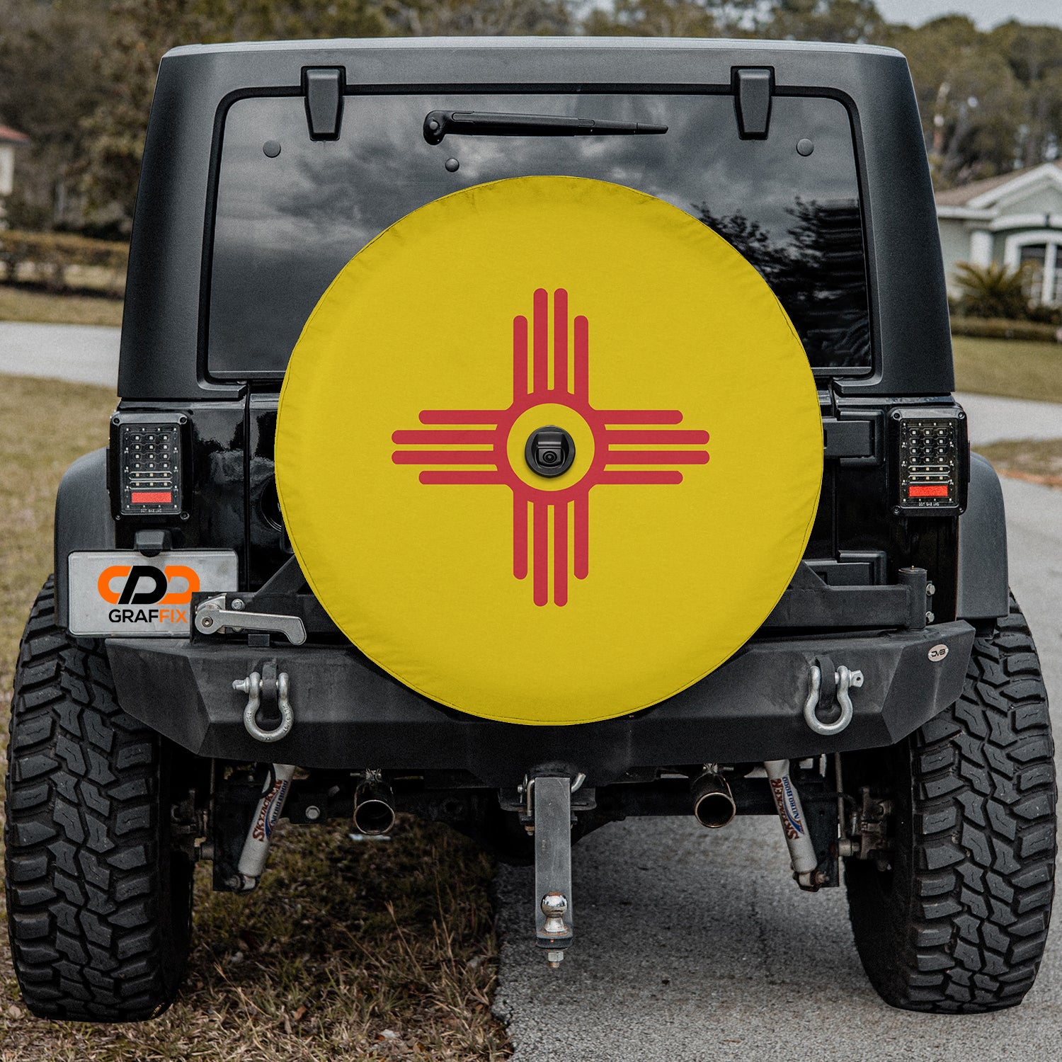 a yellow frisbee sitting on the back of a black jeep
