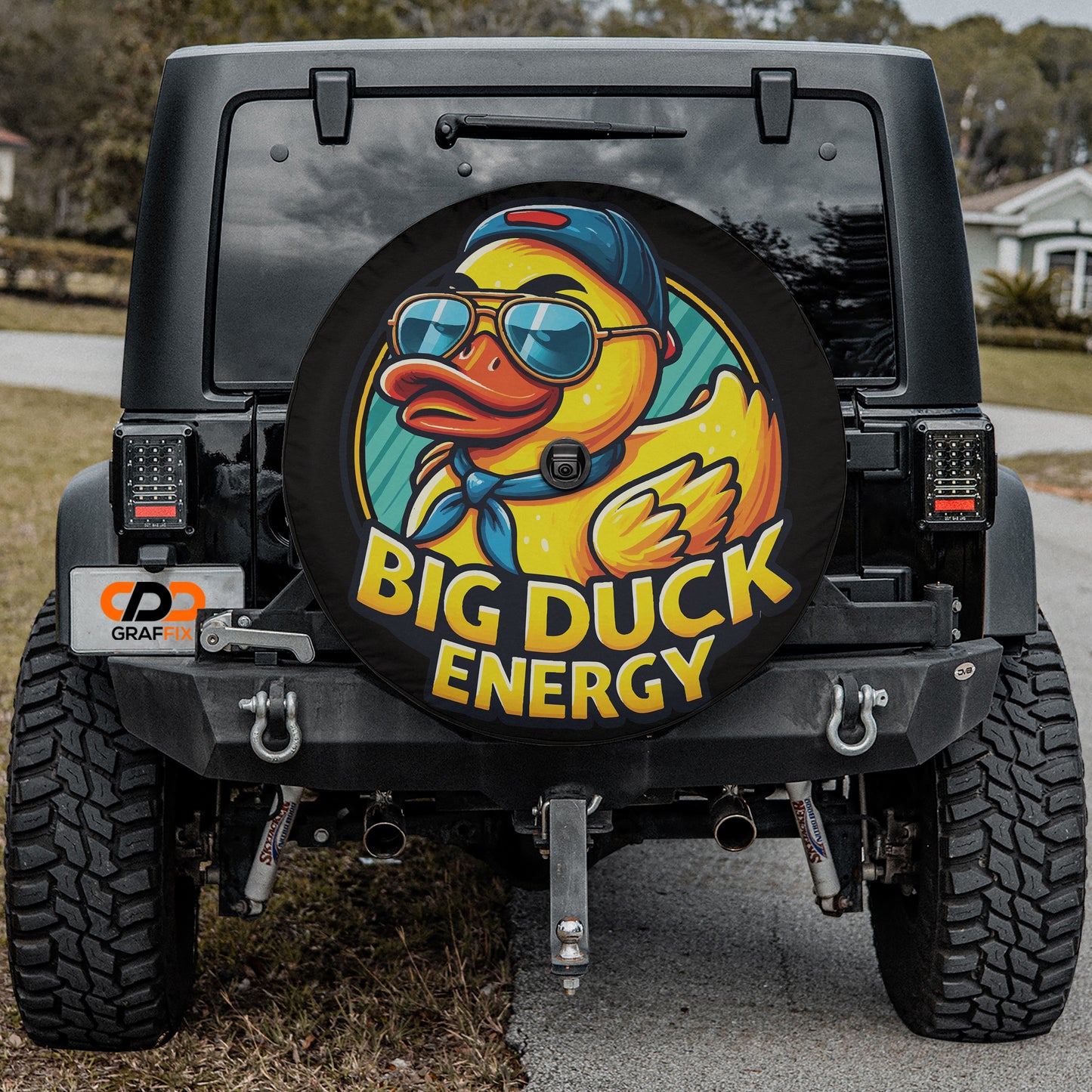 a black Jeep Wrangler with a large tire cover featuring a cartoon duck wearing sunglasses and a hat.