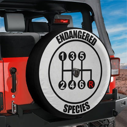 A spare tire cover with the text "ENANGERED SPECIES" printed on it, which is mounted on the rear of a red Jeep.
