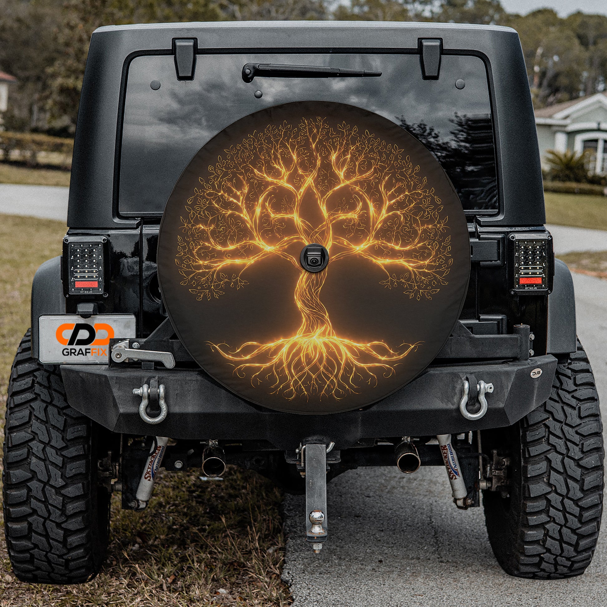 the back of a black Jeep Wrangler with a large tree-like design on the spare tire cover.