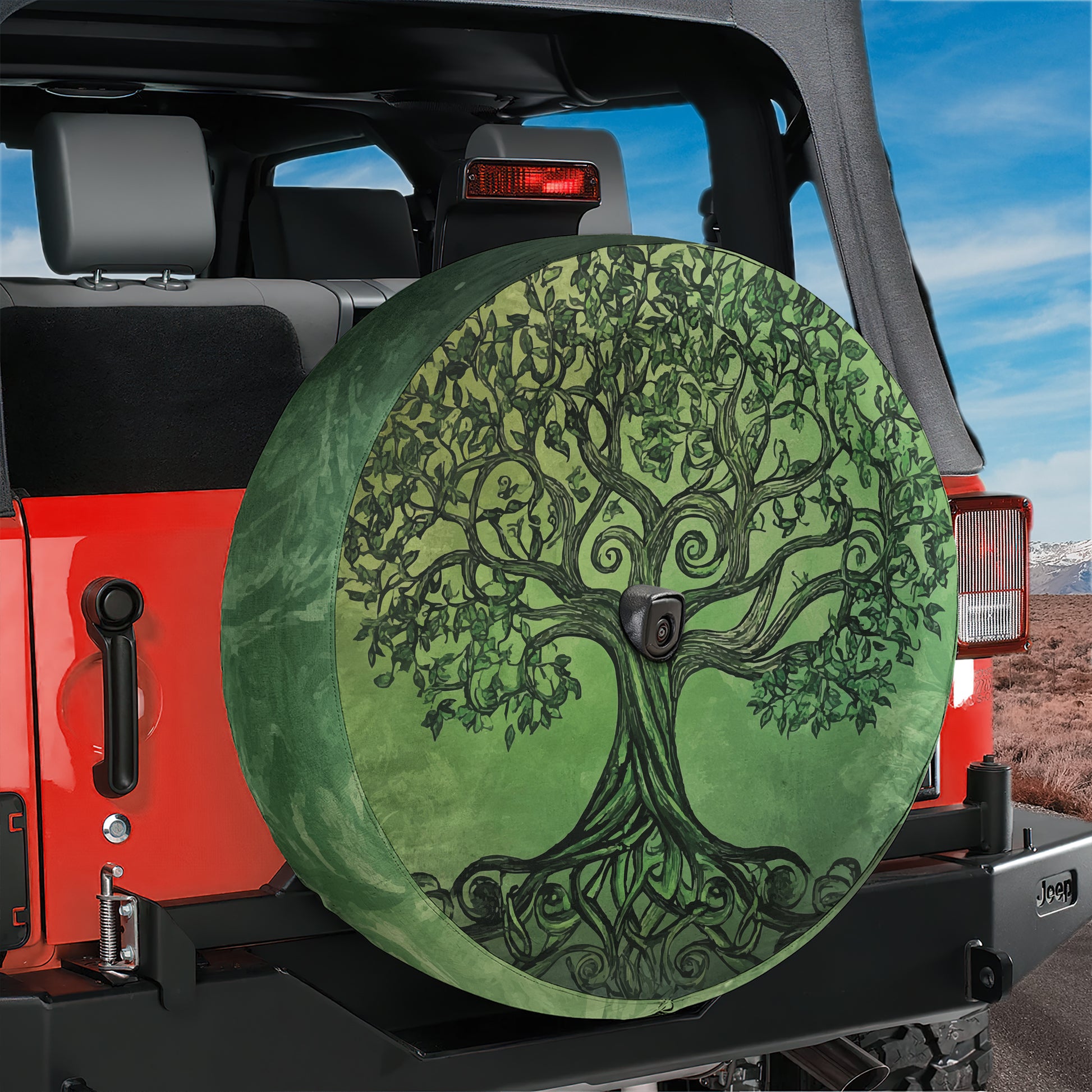 A large, green tree-like design on a spare tire cover is attached to the back of a red Jeep vehicle.