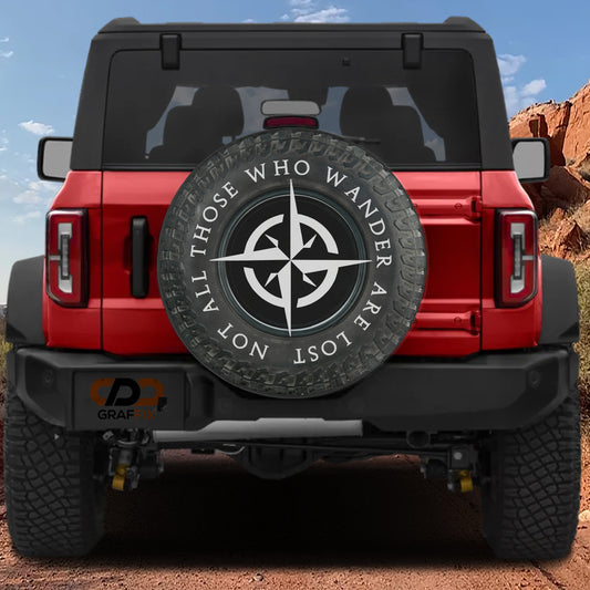 the back of a red Jeep Wrangler with a large spare tire attached to it. The spare tire has a compass design on it.