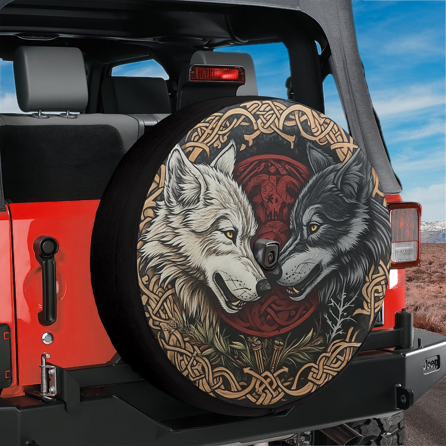A red Jeep with a large tire cover featuring a graphic of two wolves, one white and one gray, against a red and black background.