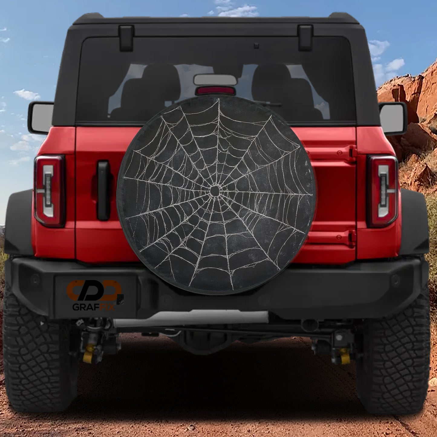 the rear view of a red Jeep Wrangler with a large black spider web decal on the rear window.
