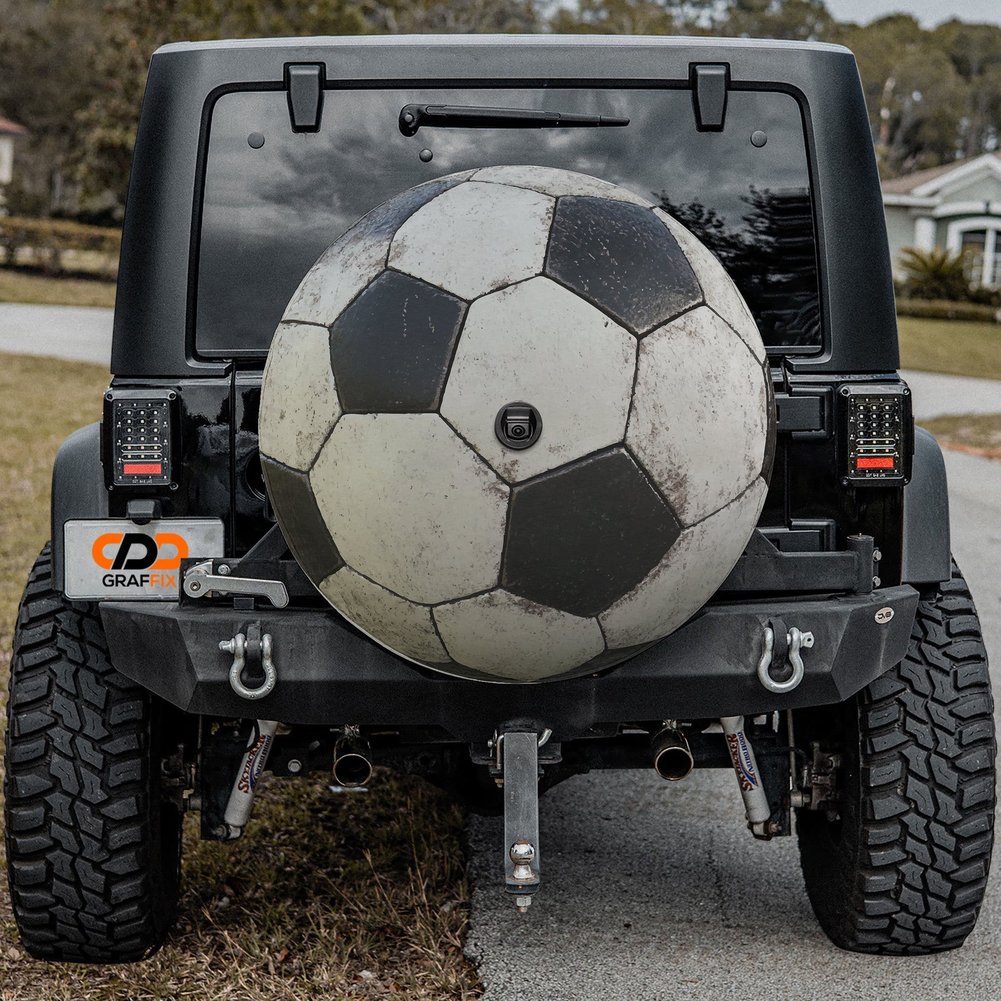 a black and white soccer ball on the back of a jeep