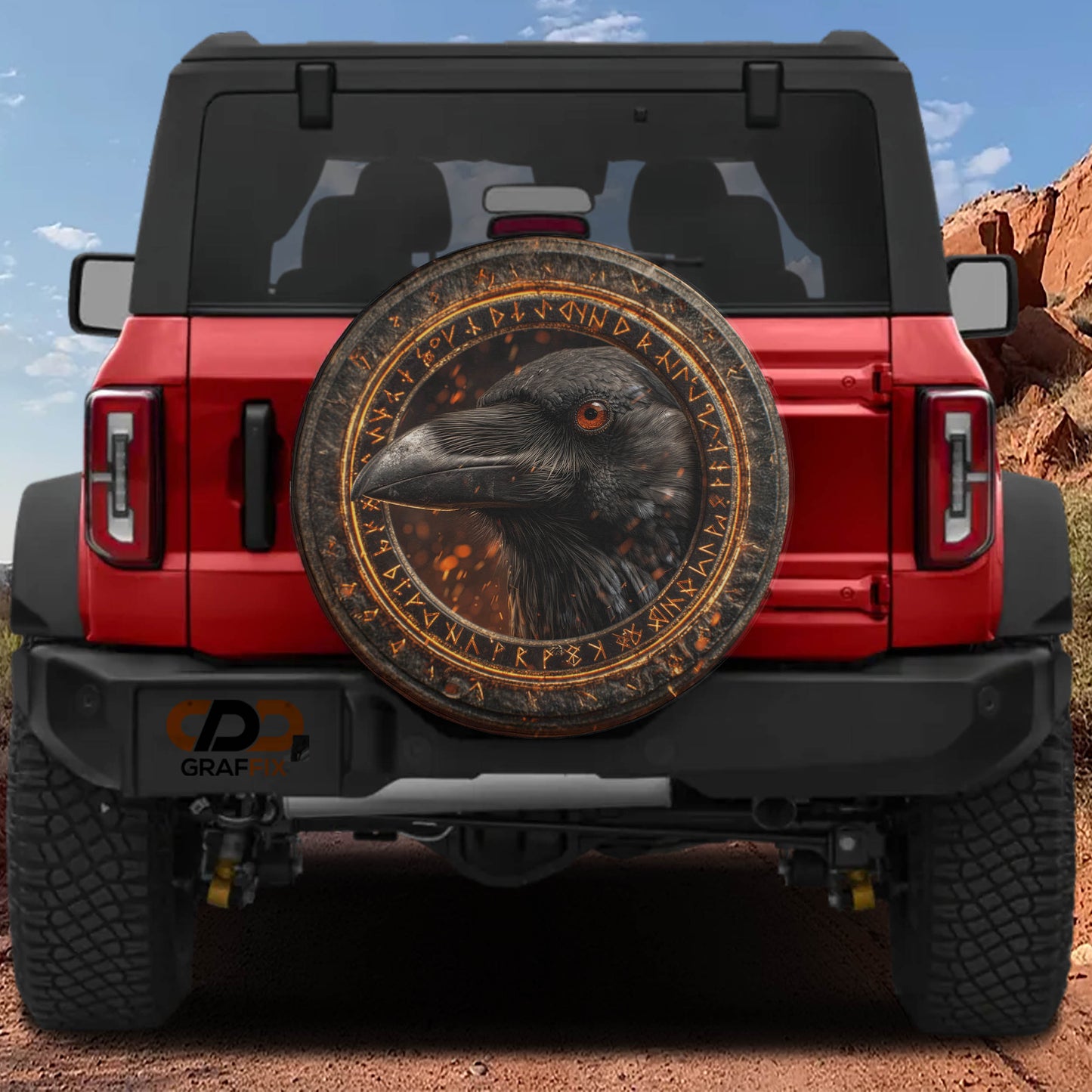 a red Jeep Wrangler with a large, ornate tire cover depicting a black crow.