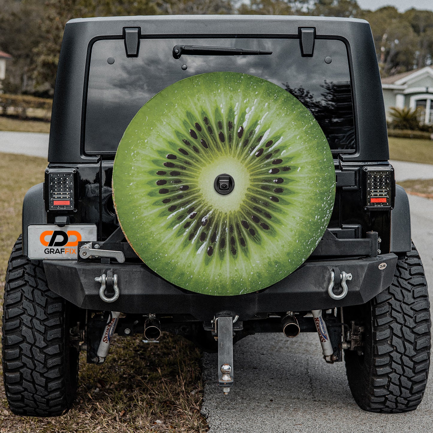 a black Jeep Wrangler with a large kiwi fruit-shaped spare tire attached to the rear of the vehicle.