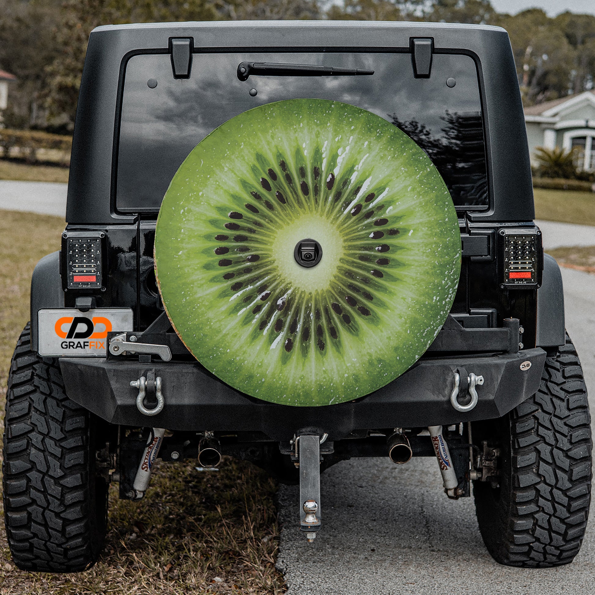a black Jeep Wrangler with a large kiwi fruit-shaped spare tire attached to the rear of the vehicle.