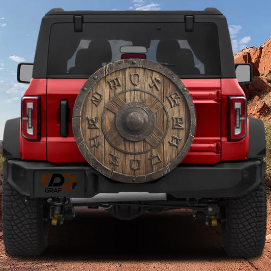 the back of a red Jeep Wrangler with a large wooden shield hanging from the rear.