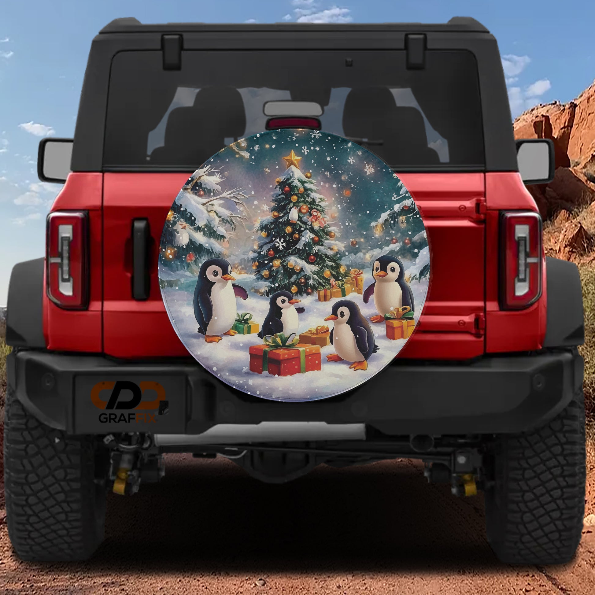A red Jeep Wrangler with a Christmas-themed spare tire on the back, featuring a snowy scene with penguins and a decorated Christmas tree.