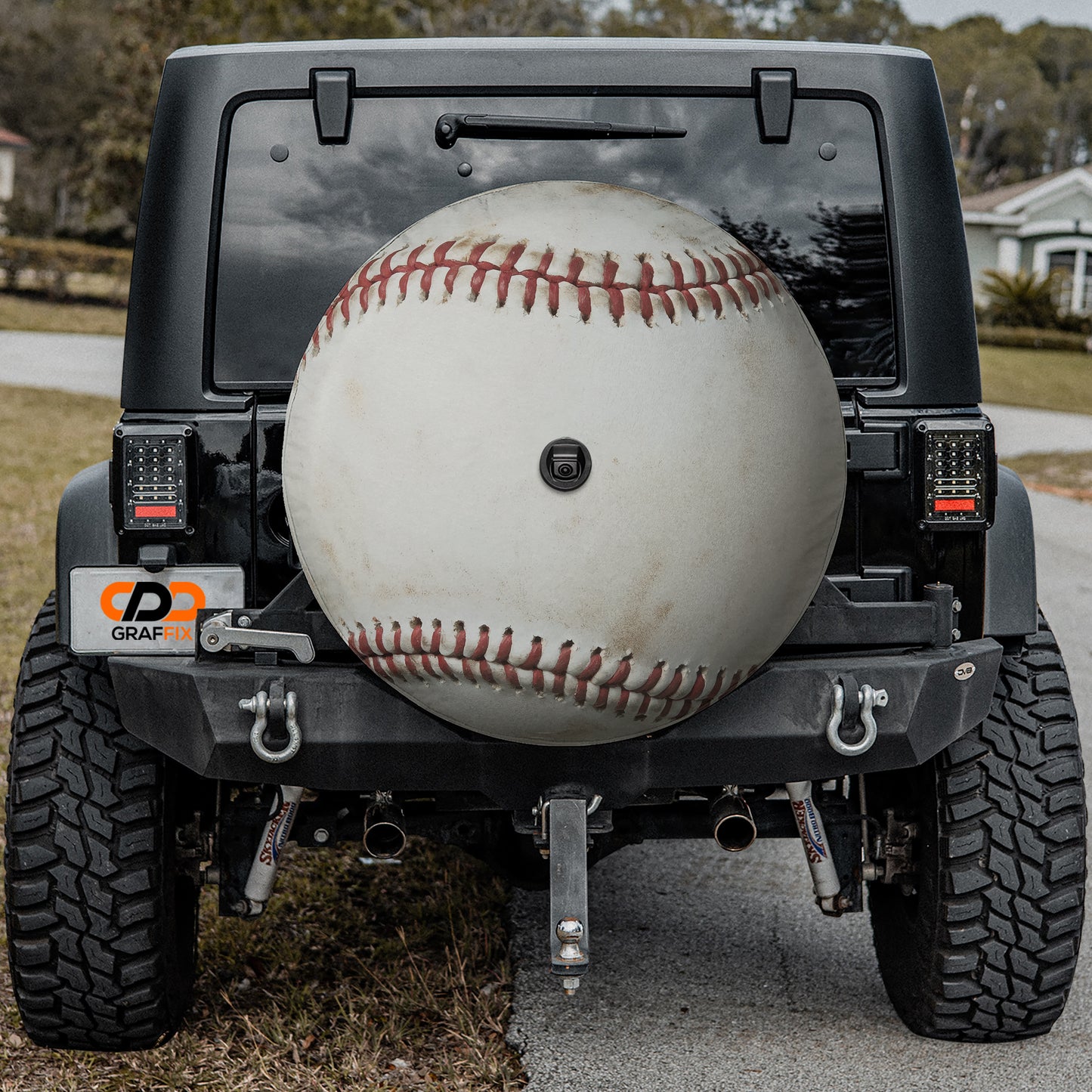 a black Jeep Wrangler with a large white baseball attached to the rear bumper.