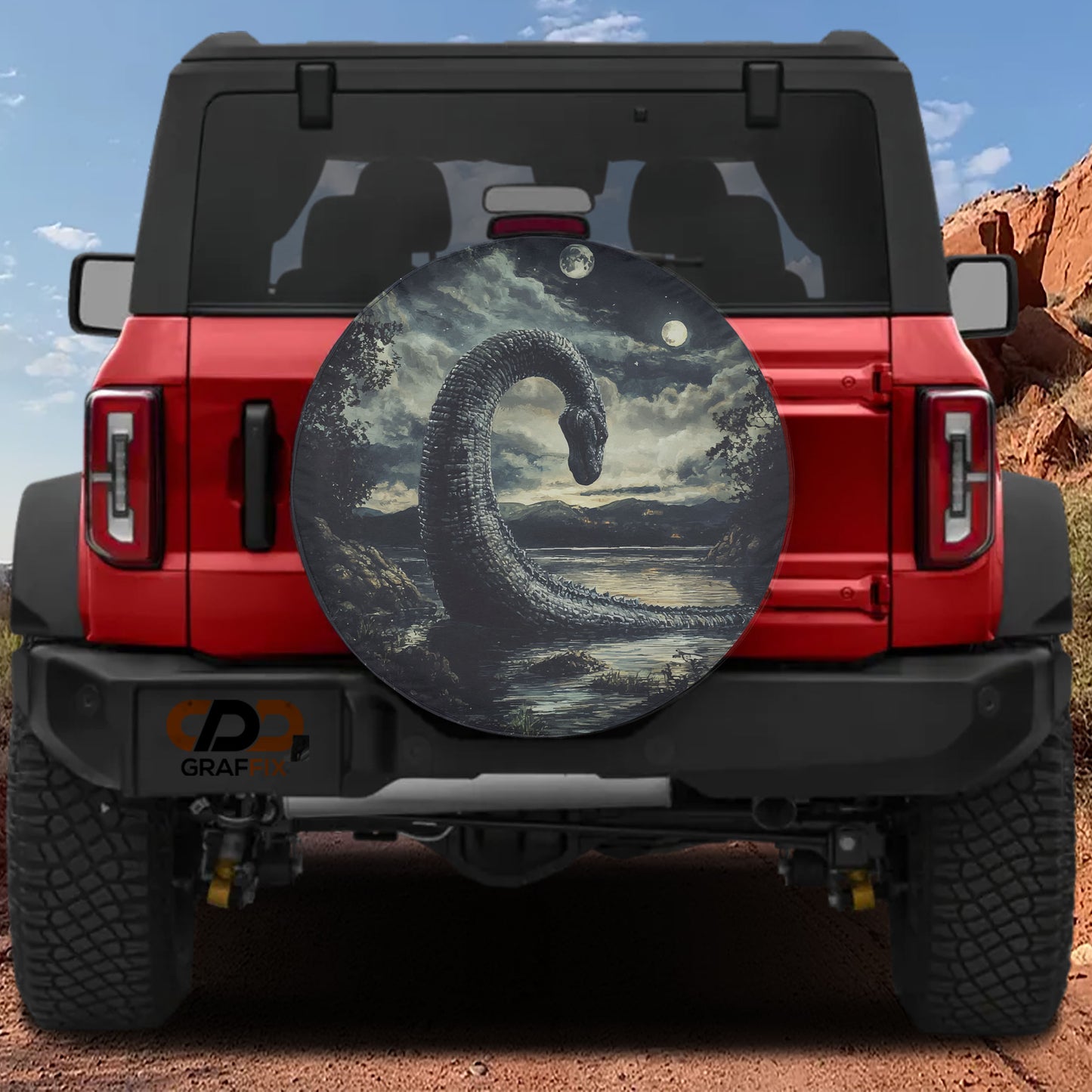 a red Jeep Wrangler with a large, circular spare tire cover depicting a large, menacing-looking creature, possibly a dragon or a monster, on the back of the vehicle.