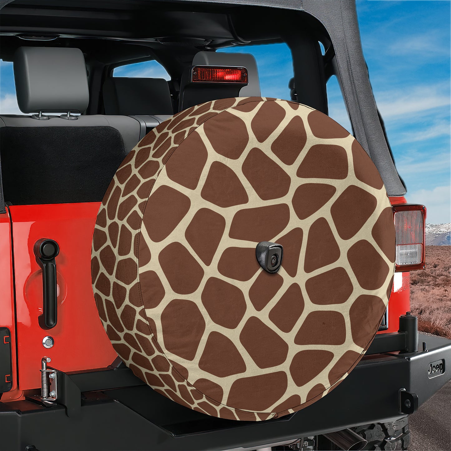 A red Jeep Wrangler with a giraffe-patterned spare tire cover attached to the rear of the vehicle.