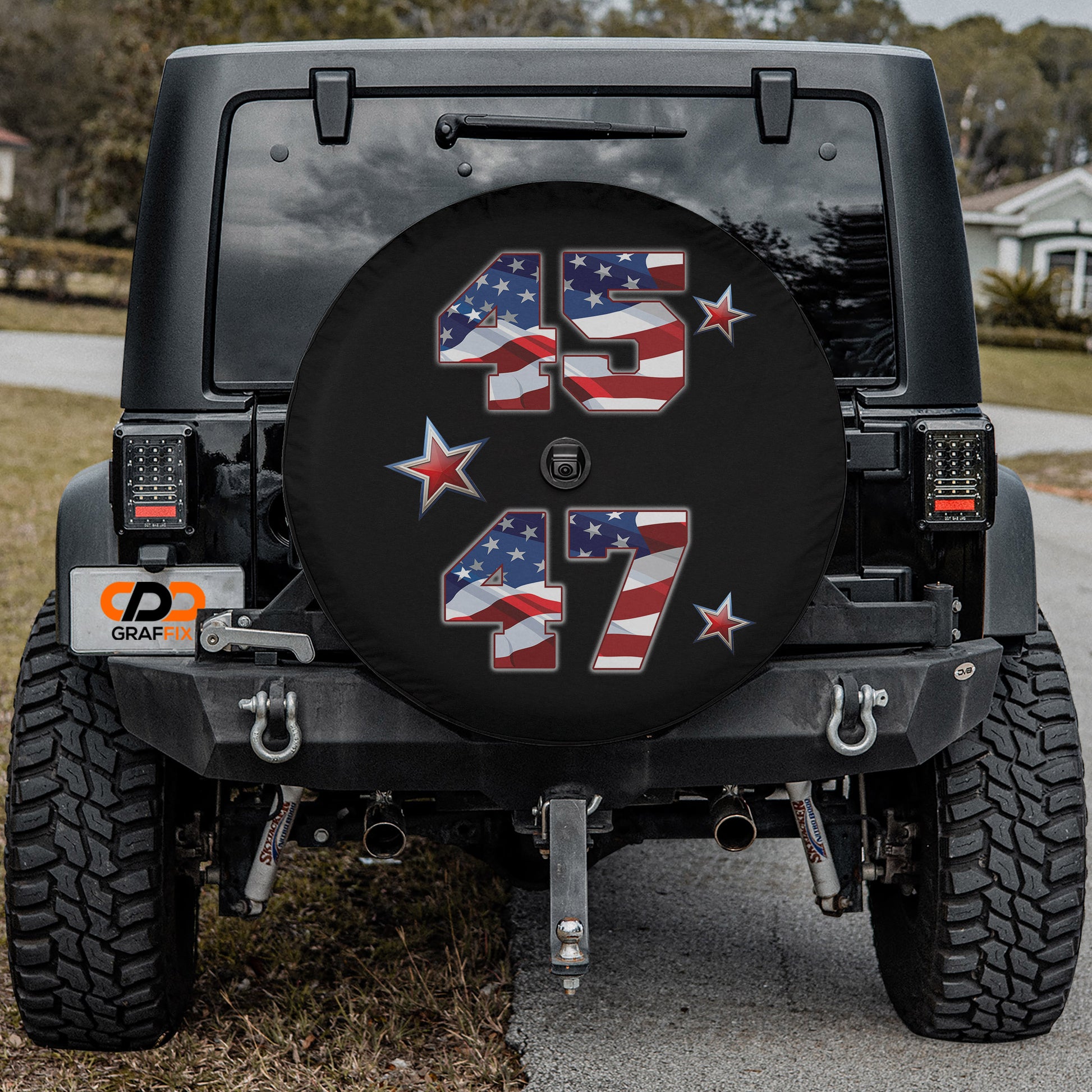 a black Jeep Wrangler with a large American flag-themed spare tire cover on the rear of the vehicle.